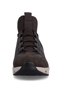 Vue de face d'une sneaker lacée marron foncé avec une épaisse semelle beige et une tirette en tissu proéminente sur la languette.