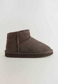 Botte brune hauteur cheville avec une texture en daim douce et un bout arrondi, présentant un détail de couture subtil et un design simple et confortable.