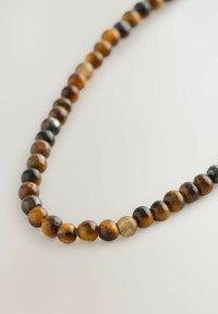 Perlenkette aus runden Tigeraugensteinen in verschiedenen Braun-, Schwarz- und Goldtönen, mit unterschiedlichen Texturen und polierten Oberflächen.
