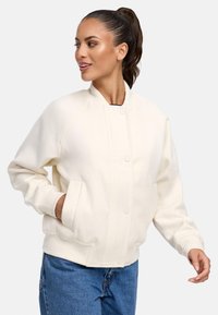 Witte, geribbelde sweatshirtjack met een ronde kraag, knoopsluiting aan de voorkant en zijzakken. Heeft een losse pasvorm en een zachte textuur.