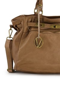 Tan leather handbag with a soft texture, featuring gold-tone hardware, a zipper, and a round charm. Slightly slouchy design with dual straps.