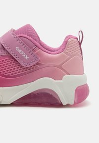 Rosa sneaker med mesh-överdel, kontrasterande nyanser, gummisula med genomskinlig rosa och stjärnmönster, och justerbar rem märkt "GEOX."
