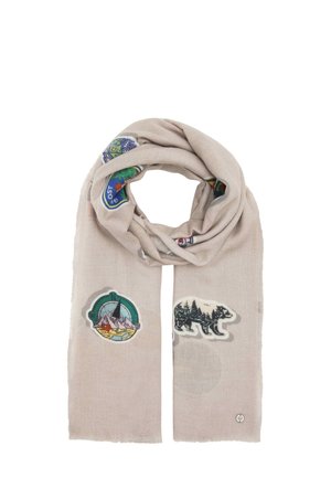 Hellbeiger Schal mit bunten naturbezogenen Patches, darunter ein Kompass mit Bergen und eine Bärensilhouette mit Bäumen innen.