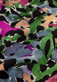 Kleurrijke bloemenstof met grote penseelstreken in roze, groen, blauw en zwart op een witte achtergrond, met een zachte textuur.