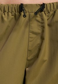 Olivengrønne shorts lavet af let, tekstureret stof med elastisk talje, justerbar snor og sidelommer.