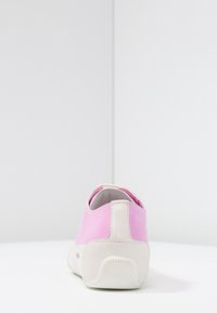 Rosa canvas slip-on sko med en strukturerad vit gummisula och en kontrasterande rosa hälaccent. Har en slät yta och minimalistisk design.