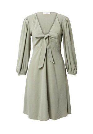 Licht saliegroene jurk met lange opgepofte mouwen, V-hals en een voorgebonden strik bij de buste, tot op de knie en met een losse pasvorm.