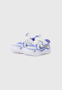 Baskets de sport blanches et bleues avec des accents jaunes, dessus en maille et semelle en caoutchouc. Équipées de bandes à velcro et d'un talon renforcé.