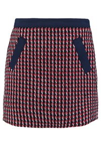 Punainen ja laivastonsininen kudottu hame, jossa on kaksivärinen ruutukuosi, joustava vyötärönauha ja sivutaskut. Kankaan pinta on teksturoitu, ja hameessa on lyhyt, A-linjainen leikkaus.