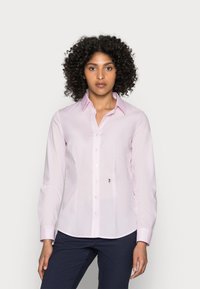 Camicia a maniche lunghe di colore rosa chiaro con colletto a punta e bottoni frontali; presenta un piccolo ricamo a forma di rosa sul lato sinistro.