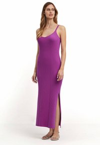 Lila geripptes Maxikleid mit dünnen Trägern, featuring einen V-Ausschnitt und einen seitlichen Schlitz. Der strukturierte Stoff verleiht dem Kleid Dimension und visuelles Interesse.