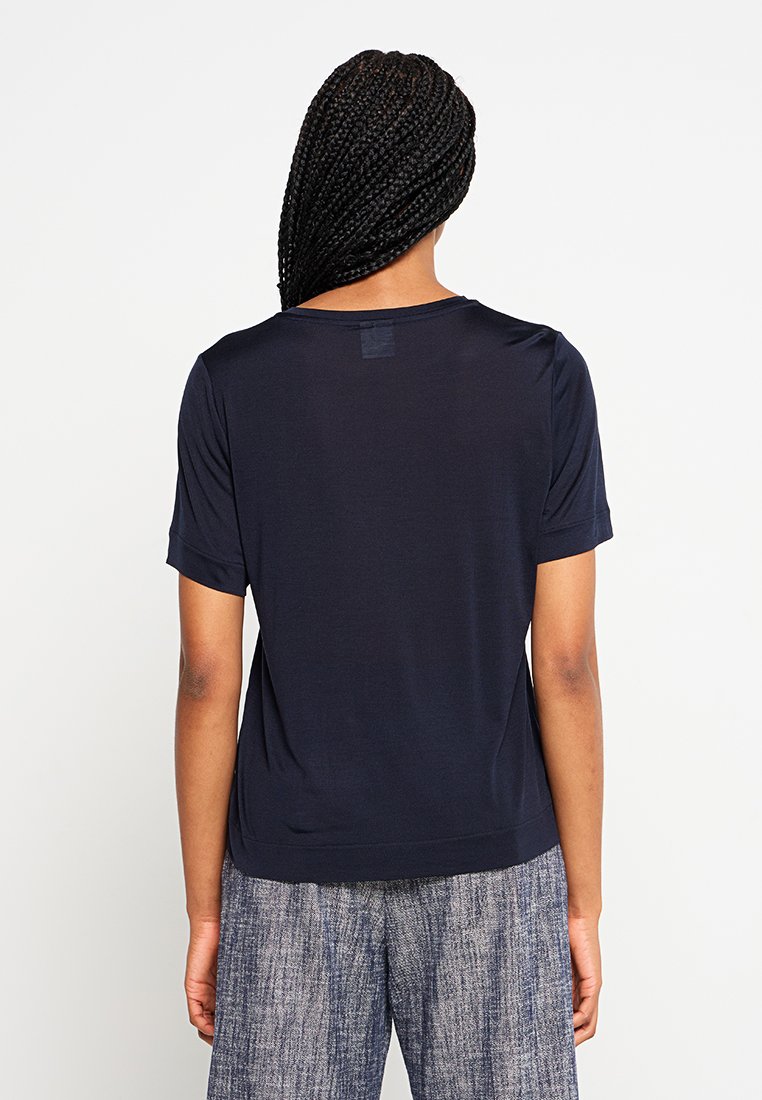 Marineblaues T-Shirt mit kurzen Ärmeln, aus glattem Stoff, mit rundem Halsausschnitt und lockerer Passform, von hinten präsentiert.