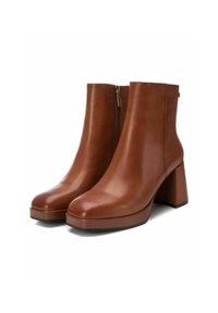 Botas de cuero marrón hasta el tobillo con puntera cuadrada, tacón alto de bloque y cierre de cremallera. Textura suave y diseño minimalista sin adornos.