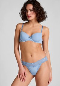 Ensemble de lingerie bleu clair comprenant un soutien-gorge rembourré avec bretelles réglables et un string assorti orné de dentelle et d'un petit nœud.