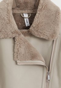 Giacca in pelle beige con un morbido colletto in pelliccia sintetica beige, dotata di chiusura con zip e tasche laterali. Tessuto liscio con un taglio moderno.