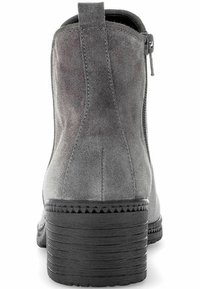 Botín de ante gris con tacón apilado, que cuenta con un zipper lateral y costuras decorativas a lo largo de la suela, textura suave y diseño minimalista.