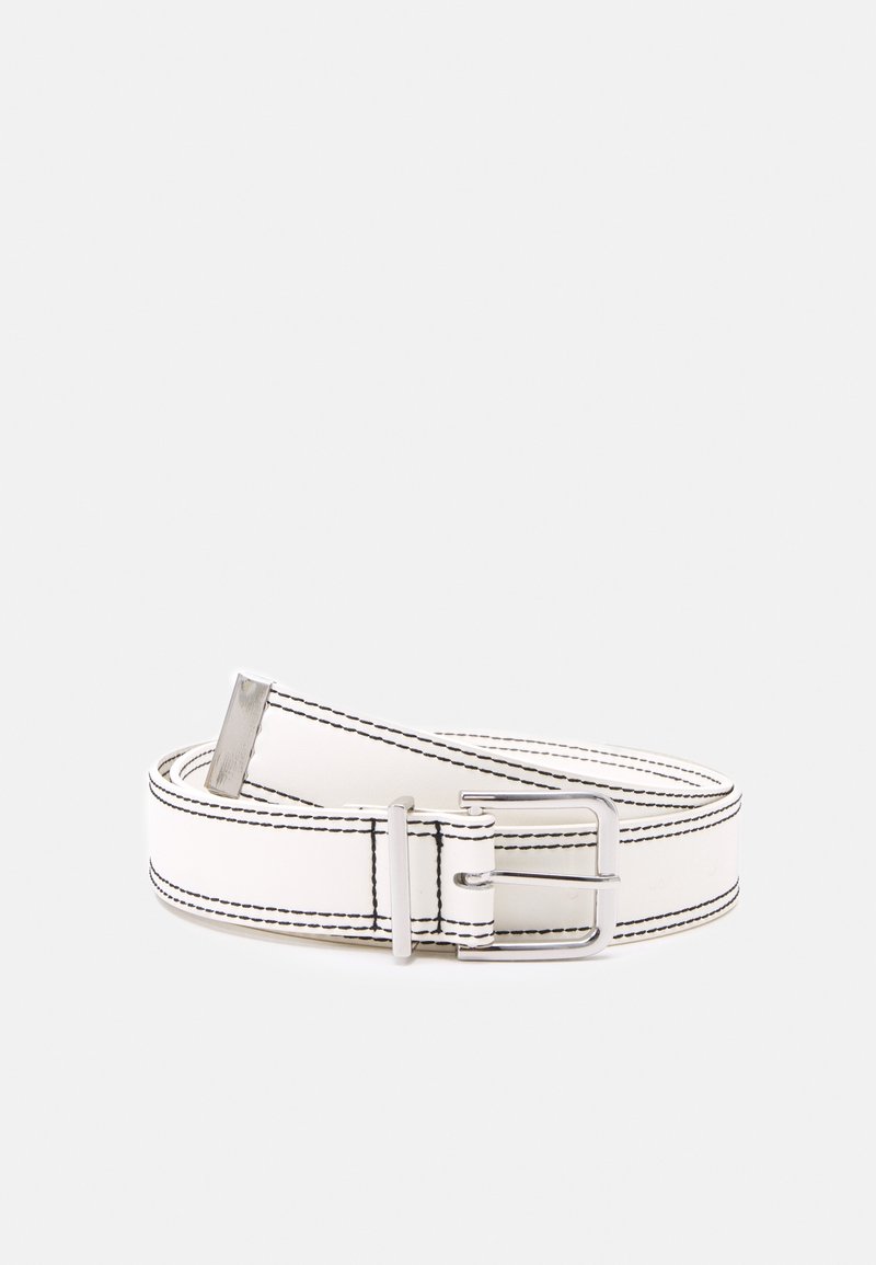 Ceinture en cuir blanc avec détaillé de couture noire et boucle métallique argentée, enroulée sur un fond gris clair uni.