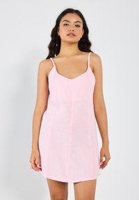 Rotes Leinenkleid mit dünnen Trägern, einem V-Ausschnitt und einer figurbetonten Silhouette, die vertikale Nahtdetails aufweist. Glatte Textur.