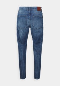 Tummansiniset farkut, joissa on slim fit -malli. Vyötäröllä nahkapatentti ja kaksi takataskua. Hieman kulunut yksityiskohta koko ajan.