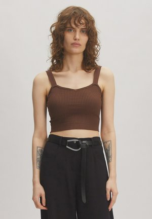 Bruine geribbelde crop top met brede banden en een vierkante halslijn, gecombineerd met hooggetailleerde zwarte broek en een zwarte riem met een zilveren accent.