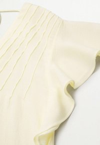 Haut jaune clair à manches courtes avec texture côtelée verticale et manches à volants, en tissu tricoté doux.