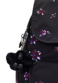 Svart blommig ryggsäck gjord av hållbart material, med lila och rosa blommönster, samt en avtagbar svart gorillanyckelring.