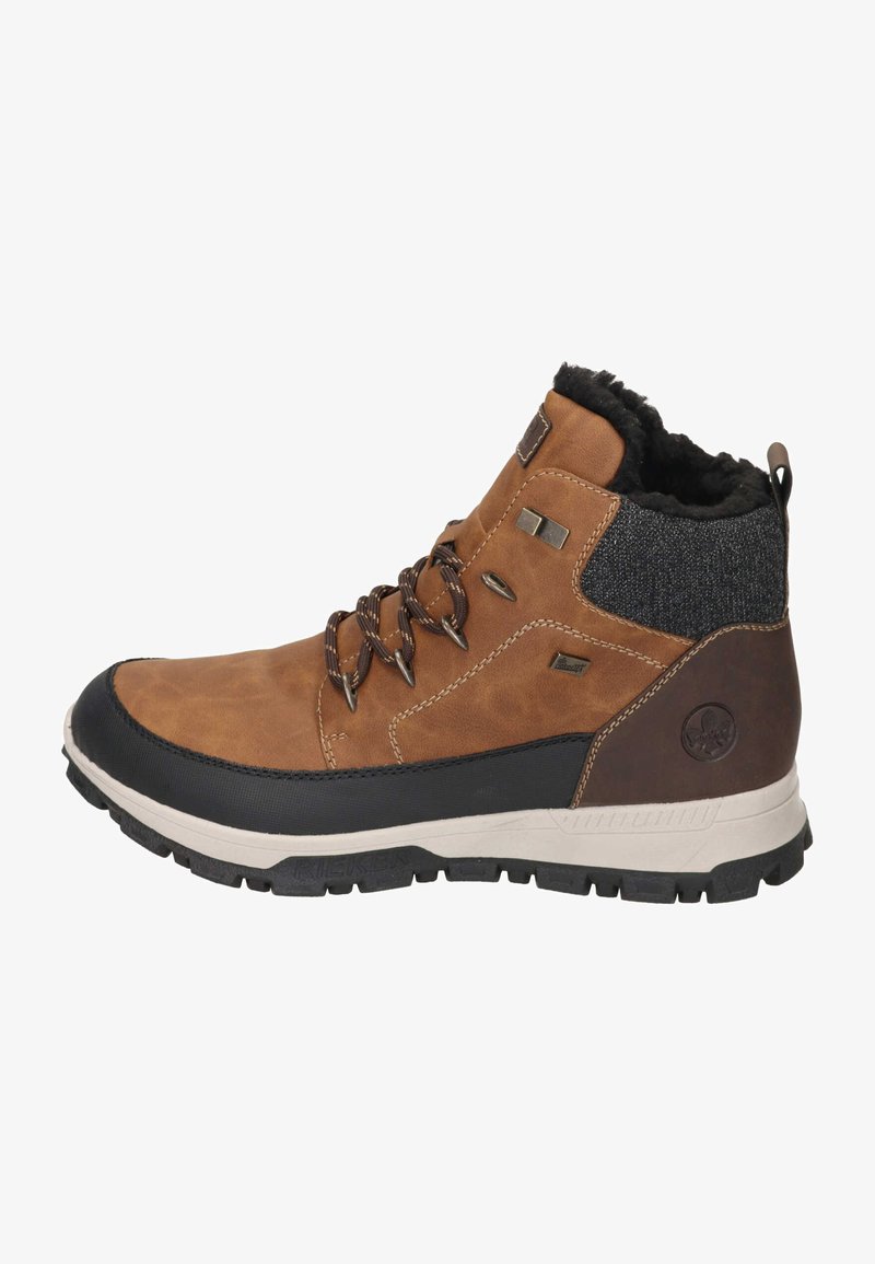 Brązowy skórzany botek za kostkę z czarną gumową podeszwą. Posiada podszewkę z sztucznego futra, metalowe oczka i ciemny tekstylny akcent z tyłu.