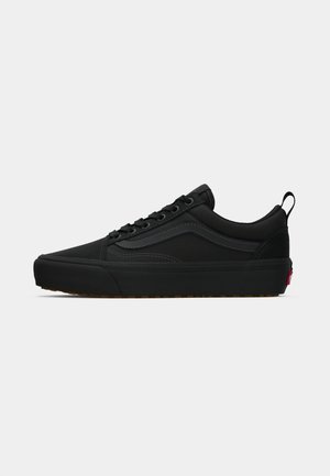 Black canvas skate shoes with a low profile, subtle gray stitching, rubber sole, and pull tab at the heel. Features classic design elements.