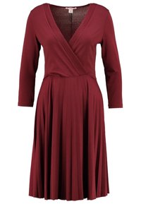 Burgundy klänning med långa ärmar, V-ringning, plisserad kjol och texturerad överdel, tillverkad av ett mjukt, elastiskt tyg.