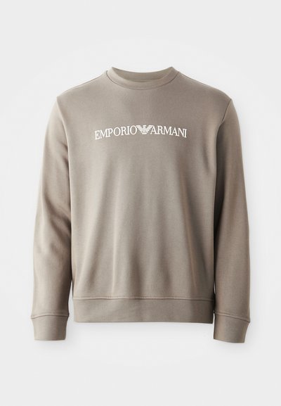 Szürke pamut kapucnis pulóver bordás mandzsettákkal és nyakkal. Jellemzője a fehér "EMPORIO ARMANI" felirat, amely a mellkason található. Puha tapintású és egyszerű dizájn.