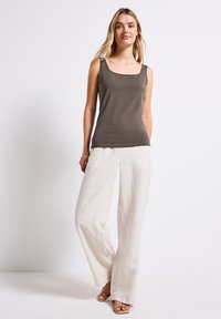 Top senza maniche grigio scuro con scollatura quadrata abbinato a pantaloni in lino beige larghi. Tessuto morbido e design a gamba larga.