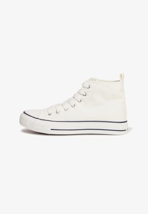 Zapatilla alta de lona blanca con punta redonda, seis ojetes, herrajes plateados y una franja azul marino a lo largo de la suela. Textura suave, diseño minimalista.