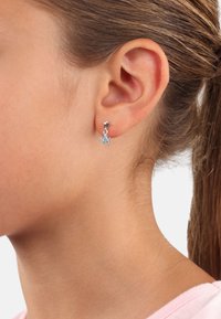 Orecchini in argento sterling a forma di stella, con una pietra blu chiara a forma di stella pendente da un piccolo perno a forma di stella in argento.