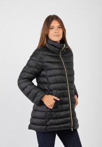 Giacca nera imbottita con colletto alto, chiusura con zip e tasche laterali. Caratterizzata da una finitura lucida e cuciture orizzontali per texture.
