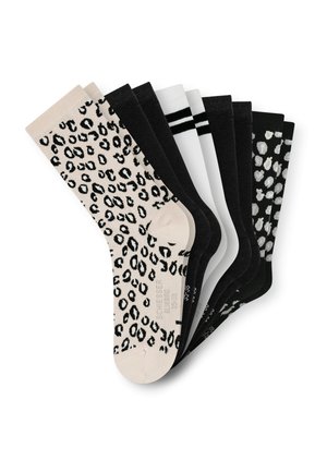Ensemble de six chaussettes de couleurs variées : une beige avec un imprimé léopard noir, quatre noir unis, une blanche avec des rayures noires et une blanche avec des taches noires.