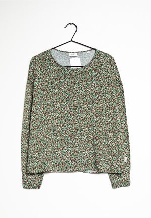 Długi rękaw bluzka z brązowego materiału z kwiatowym wzorem w zieleni i bieli. Ma okrągły dekolt i luźny krój.