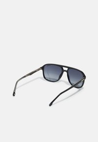 Ochelari de soare negri cu un cadru dreptunghiular elegant, lentile întunecate cu un gradient, și accente de nuanță aurie pe brațe. Textură netedă și design modern.