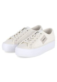 Sneakers bianchi in tela con pannello laterale testurizzato, design con lacci e una spessa suola in gomma bianca. Presentano un piccolo etichetta del marchio sul lato.