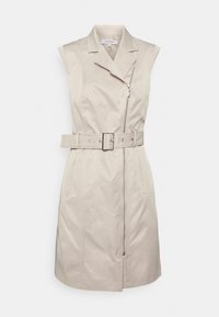 Beige ærmeløs kjole med lynlås foran, belagt talje og to sidelommer; glat stof, skræddersyet design og struktureret krave.