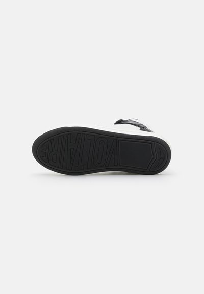 Black rubber sole with textured grip pattern. White midsole features embossed "VOLTARE" logo. Upper details not visible in view.