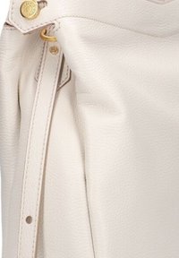 Borsa a mano in pelle crema caratterizzata da una superficie texturizzata, accenti in metallo dorato e una zip laterale con design a ribalta. Dettagli di cucitura delicati.