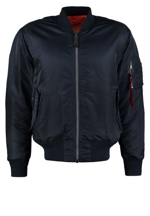 Veste bombardier navy avec fermeture éclair devant, poignets et ourlet côtelés, poches latérales, et une poche utilitaire sur la manche avec une tirette rouge.