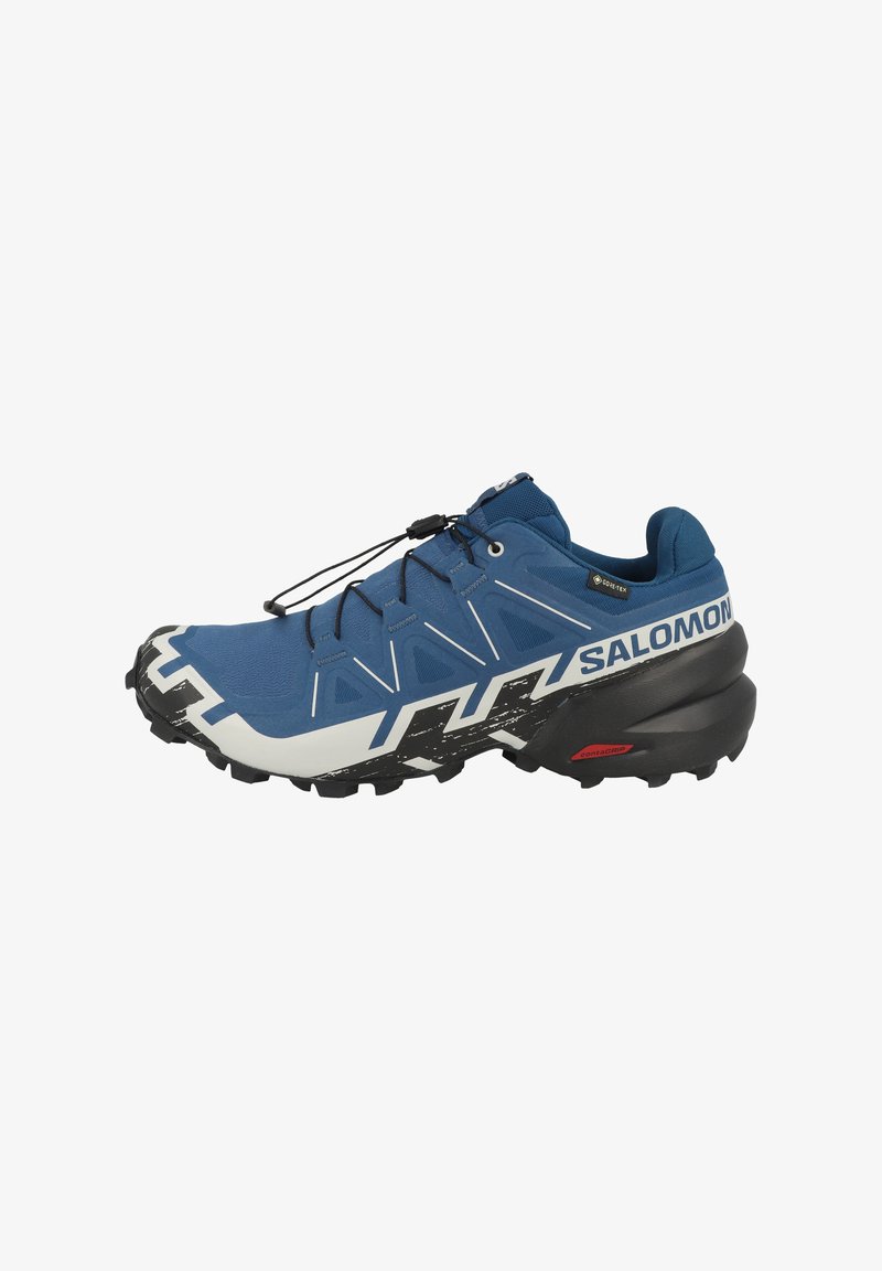 Scarpa outdoor blu con tomaia testurizzata, suola nera e bianca, lacci elastici e lati rinforzati con il logo del marchio "Salomon".