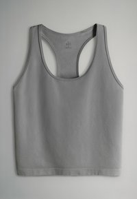 Sivý tank top z mäkkej tkaniny. Bez rukávov s dizajnom racerback a kontrastným prešívaním pozdĺž okrajov. Rovný lem v spodnej časti.