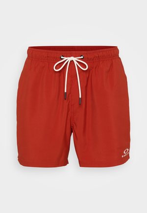 Rote Badehosen aus leichtem Material, mit einem elastischen Bund und einer weißen Kordel sowie einem Logo auf der unteren rechten Seite.