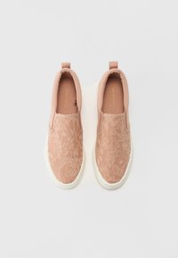 Rosa slip-on sko med blonderoverlegg, avrundet tå, hvit gummisåle og løftestroppe på hælen for enkel påkledning.