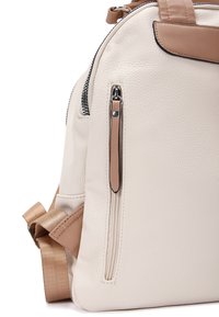 Witte leren rugzak met een gestructureerde afwerking, tan accenten, een ritsvak en verstelbare schouderbanden. Heeft een ronde vorm en metalen hardware.