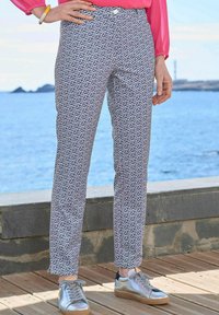 Marineblauwe en witte geprinte broek van lichtgewicht stof, met een geometrisch ontwerp, slim fit en standaard taille, gecombineerd met metallic sneakers.