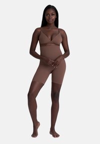 Brauner nahtloser Shapewear-Set mit einem Bralette mit dünnen Trägern und Shorts bis zur Mitte des Oberschenkels, entworfen für Komfort und eine glatte Silhouette.