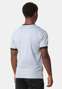 Hellgraues Sport-T-Shirt mit kurzen Ärmeln, schwarzen Akzenten am Kragen und an den Ärmeln sowie einer glatten Textur. Es hat einen runden Halsausschnitt.